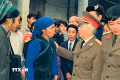 Bức ảnh bà Dương Thị Hỷ (77 tuổi, xóm Bản Um, xã Tam Kim, tỉnh Cao Bằng) địu cháu được ghi lại trong dịp Đại tướng về thăm Tam Kim năm 1994. (Ảnh: TTXVN phát)