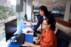 Cán bộ Trung tâm Phục vụ hành chính công thành phố Hà Nội thực hiện giải quyết thủ tục hành chính cho người dân. (Ảnh: Vũ Quang/TTXVN)