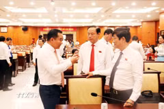 Ông Nguyễn Văn Được, Chủ tịch Ủy ban Nhân dân Thành phố Hồ Chí Minh, trao đổi với ông Võ Văn Minh, Chủ tịch Hội đồng Nhân dân Thành phố. (Ảnh: Xuân Khu/TTXVN)