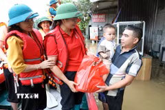Bà Vũ Thị Quyên, Phó Chủ tịch Hội Chữ thập đỏ tỉnh Lạng Sơn trao quà cho hộ dân có nhà bị ngập tại xã Thất Khê, tỉnh Lạng Sơn. (Ảnh: Văn Đạt/TTXVN)