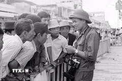 Phóng viên Hứa Kiểm của Thông tấn xã Việt Nam gặp gỡ quần chúng nhân dân Sài Gòn để đưa tin, ảnh về thắng lợi của Chiến dịch Hồ Chí Minh lịch sử 1975, giải phóng hoàn toàn miền Nam, thống nhất đất nước. (Ảnh: TTXVN)