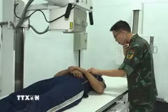 Bác sỹ Bệnh xá Đảo Song Tử Tây đang thăm khám cho bệnh nhân Đặng Ân. (Ảnh: TTXVN phát)