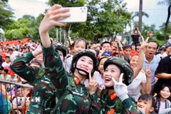 Các nữ chiến sỹ thông tin chụp ảnh kỷ niệm với người dân Hà Nội trước giờ tổng hợp luyện sự kiện A80. (Ảnh: Hoàng Hà/TTXVN)