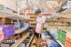 Học sinh tìm mua sách giáo khoa. (Ảnh: Hoàng Ngà/TTXVN)