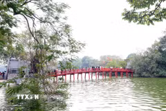 Du khách tham quan tại khu di tích cầu Thê Húc, đền Ngọc Sơn. (Ảnh: Phạm Kiên/TTXVN)