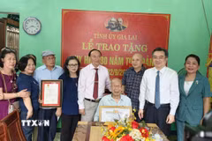 Đồng chí Nguyễn Thanh Nghị trao Huy hiệu 80 tuổi Đảng cho đảng viên Phan Ngọc Bích, Chi bộ Tổ dân phố 6, Đảng bộ phường Quy Nhơn. (Ảnh: Sỹ Thắng/TTXVN)