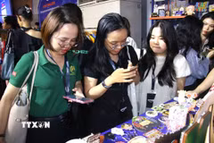 Nhà bán hàng tìm hiểu sản phẩm từ nhà cung cấp tại sự kiện. (Ảnh: Hương Giang/TTXVN)