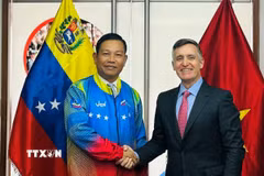 Đại sứ Vũ Trung Mỹ mặc áo đội tuyển Olympic quốc gia Venezuela do Bộ trưởng Franklin Cardillo trao tặng. (Ảnh: ĐSQ cung cấp)