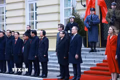 Thủ tướng Phạm Minh Chính và Thủ tướng Cộng hòa Ba Lan Donald Tusk nghe quân nhạc cử Quốc thiều hai nước. (Ảnh: Dương Giang/TTXVN)