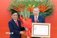 Đồng chí Trần Cẩm Tú, Ủy viên Bộ Chính trị, Thường trực Ban Bí thư trao Huy hiệu Đảng và tặng hoa chúc mừng Tổng Bí thư Tô Lâm. (Ảnh: Thống Nhất/TTXVN)