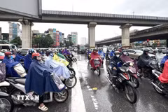 Người dân vất vả di chuyển trong điều kiện thời tiết không thuận lợi và giao thông ùn tắc tại ngã tư Nguyễn Xiển-Nguyễn Trãi. (Ảnh: Quốc Lũy/TTXVN)