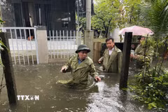 Bí thư Đảng ủy xã Núi Thành Nguyễn Như Công và các thành viên đến từng khu dân cư bị ngập nước để vận động nhân dân di chuyển đến nơi an toàn. (Ảnh: Đoàn Hữu Trung/TTXVN)