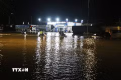 Các phương tiện gặp khó khăn khi lưu thông qua khu vực nước trên Quốc lộ 1A. (Ảnh: Phạm Cường/TTXVN)