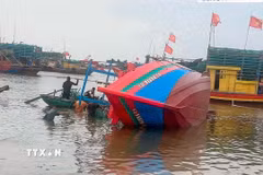 Tàu cá TH-91594-TS của ông Cao Văn Chung (sinh năm 1977) trú tại tổ dân phố Đồng Minh, phường Ngọc Sơn trong thời gian neo đậu tại khu vực Lạch Ghép, thuộc tổ dân phố Đồng Minh thì bất ngờ bị chìm. (Ảnh: TTXVN phát)
