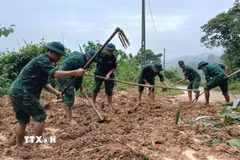 Các cán bộ, chiến sỹ Đồn Biên phòng Ba Nang khẩn trương dọn dẹp, khắc phục các điểm sạt lở do mưa lớn. (Ảnh: TTXVN phát)
