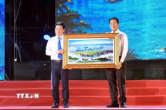 Phó Chủ tịch Thường trực UBND tỉnh Khánh Hòa Nguyễn Long Biên (bên phải) tặng quà lưu niệm đến lãnh đạo UBND tỉnh Quảng Trị. (Ảnh: Tá Chuyên/TTXVN)