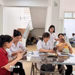Người dân xã Đạo Trù được cán bộ y tế xã hướng dẫn cài đặt, sử dụng Sổ sức khoẻ điện tử. (Ảnh: Nguyễn Thảo/TTXVN)