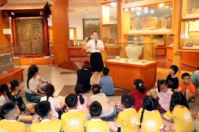 Cán bộ Bảo tàng tỉnh Ninh Bình giới thiệu những hiện vật được lưu giữ tại bảo tàng cho các em học sinh. (Ảnh: Nguyễn Lành/TTXVN)