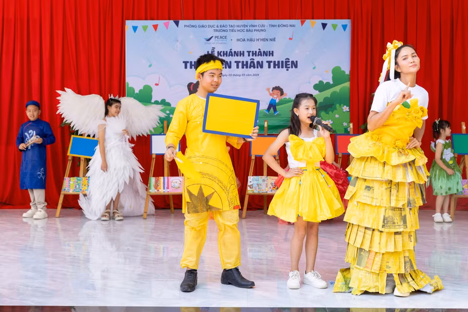 Đặc biệt, H’Hen Niê trình diễn cùng các em học sinh trong phần “Thời trang mã màu” hướng dẫn việc chọn sách theo mã màu từng khối lớp khi vào tham quan thư viện. Cô mặc trang phục mã màu vàng dành cho học sinh khối lớp 5 với những quyển sách cung cấp kiến thức với ít tranh minh họa. (Ảnh: CTV/Vietnam+)