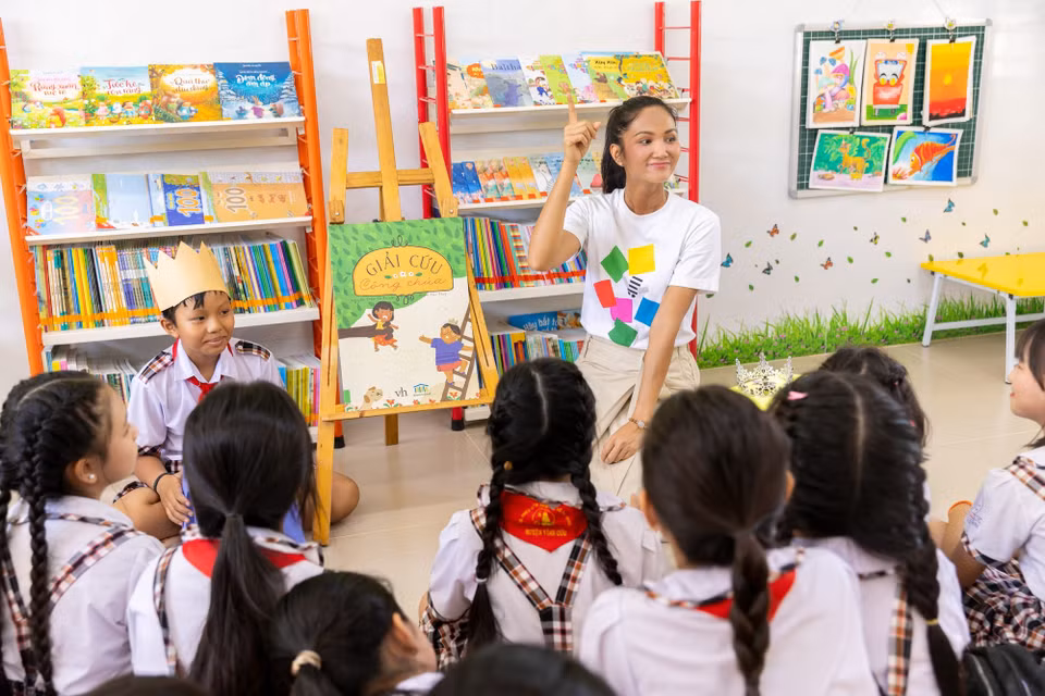 H’Hen Niê cùng các em học sinh vào thư viện và trực tiếp đọc sách cho các em nghe, với phần minh họa sinh động có hoàng tử và công chúa. (Ảnh: CTV/Vietnam+)