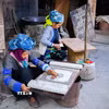 Người phụ nữ Mông tại Lùng Tám thực hiện công đoạn vẽ sáp ong lên vải lanh trước khi nhuộm chàm. (Ảnh: Lan Anh/TTXVN phát)
