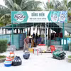 Các hộ kinh doanh thu gom, sắp xếp bàn ghế, thiết bị và vật dụng trước khi vận chuyển khỏi khu vực bãi biển Nhật Lệ. (Ảnh: Tá Chuyên/TTXVN)