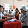 Nhiều người dân đến làm thủ tục hành chính tại nhà văn hóa thôn Chơ Ré (nay là thôn Tân Hạ, xã Tà Năng). (Ảnh: Nguyễn Dũng/TTXVN)