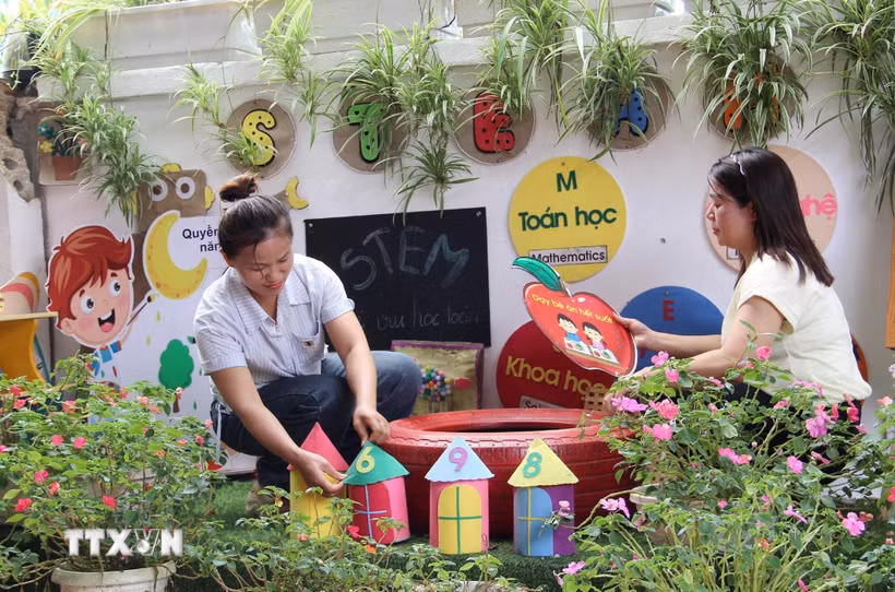 Giáo viên Trường Mầm non Thanh Lòa, xã Cao Lộc, chuẩn bị góc vui chơi cho học sinh. (Ảnh: TTXVN phát)