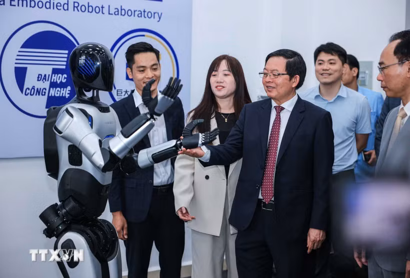 Phó Thủ tướng Hồ Quốc Dũng và các đại biểu tham quan robot tại Trung tâm thực hành tập trung của Trường Đại học Công nghệ. (Ảnh: Hoàng Hiếu/TTXVN)