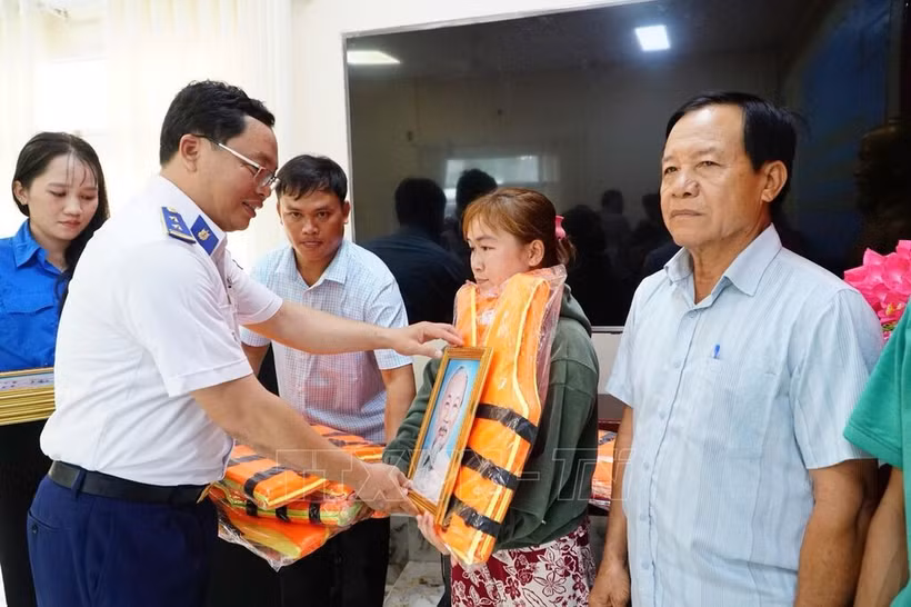 Đại diện Bộ Tư lệnh Vùng Cảnh sát biển 4 tặng cờ Tổ quốc, ảnh Bác Hồ và áo phao cho ngư dân xã Hòa Điền, tỉnh An Giang.