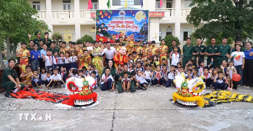 Cán bộ, chiến sỹ Đồn Biên phòng Tam Thanh chụp ảnh lưu niệm cùng các học sinh. (Ảnh: Quốc Dũng/TTXVN)