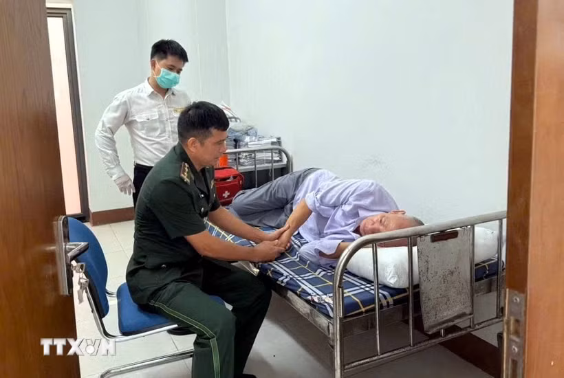 Cán bộ Trạm Kiểm soát Biên phòng cửa khẩu quốc tế Móng Cái (Bộ đội Biên phòng thành phố Quảng Ninh) phối hợp với lực lượng kiểm dịch y tế quốc tế sơ cứu du khách Liang RuiZhuang bị ngất tại cửa khẩu quốc tế Móng Cái. (Ảnh: TTXVN phát)