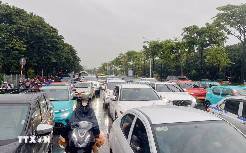 Các phương tiện nối đuôi nhau do ùn tắc cục bộ trên đường Đàm Quang Trung từ cầu vượt Vĩnh Tuy đến ngã tư Cổ Linh-Đàm Quang Trung do ngập và các công trình đang thi công. (Ảnh: Phan Phương/TTXVN)