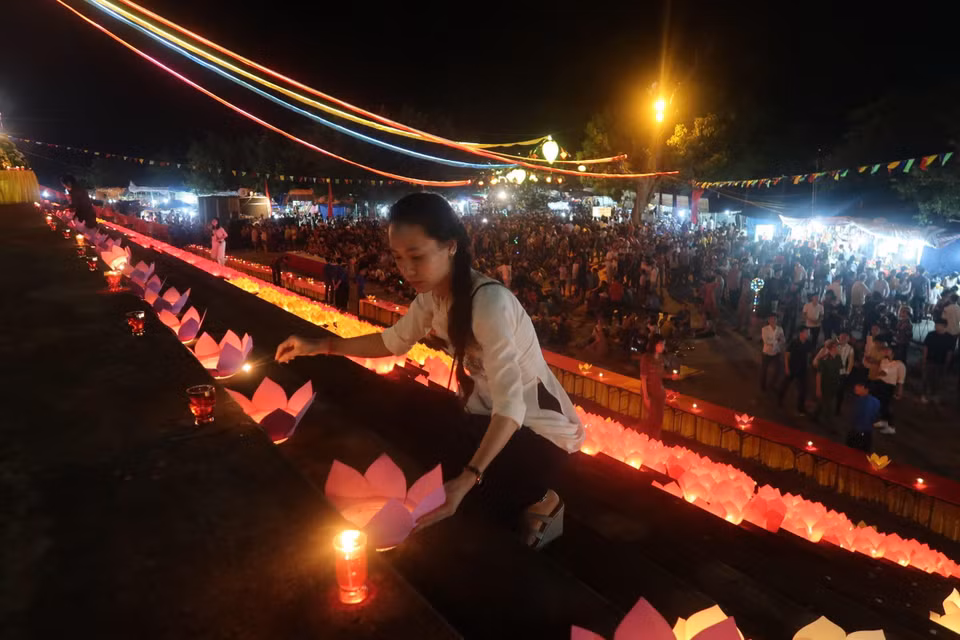 Thắp nến tại Hội hoa đăng. (Ảnh: Hiền Anh/TTXVN)
