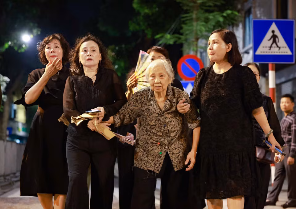 21h45 phút, một người cao tuổi được con cháu đưa tới Nhà tang lễ viếng Tổng Bí thư Nguyễn Phú Trọng. (Ảnh: Thanh Tùng/TTXVN)
