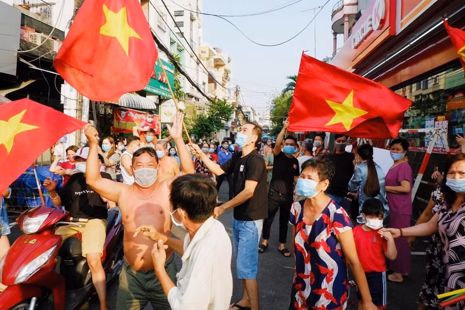 Người dân hẻm 245 Nguyễn Trãi (phường Nguyễn Cư Trinh, Quận 1, Thành phố Hồ Chí Minh) vui mừng khi được gỡ bỏ phong tỏa vào chiều mùng 4 Tết. (Ảnh: TTXVN phát)