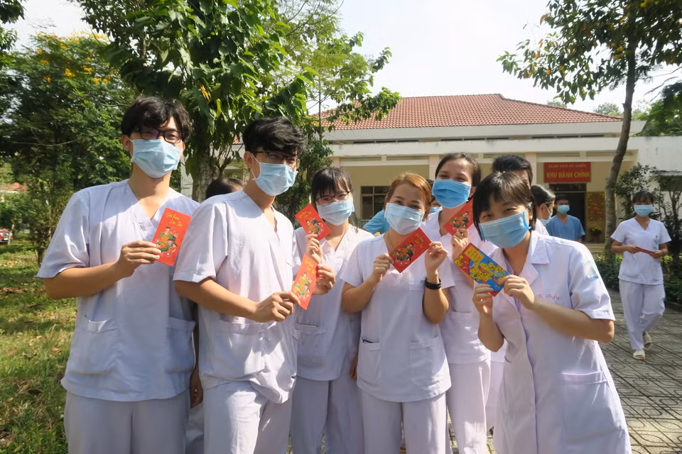 Nhân viên y tế trực Tết tại Bệnh viện Dã chiến Củ Chi nhận ''lì xì'' của lãnh đạo Sở Y tế Thành phố Hồ Chí Minh. (Ảnh: Đinh Hằng/TTXVN)