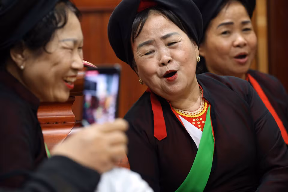 Nghệ nhân ưu tú Nguyễn Thị Ly (giữa) cùng các liền chị đối đáp trong đêm hát canh. (Ảnh: Nhật Anh/TTXVN)