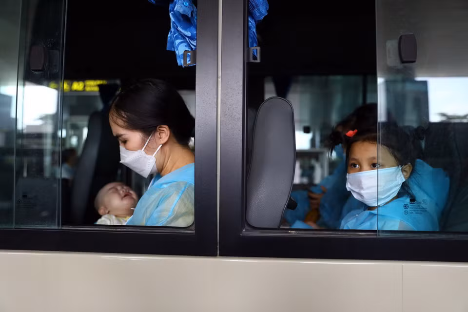 Chị Đào Thị Viên và con nhỏ mua được vé máy bay về nước sau 10 tháng kẹt tại Hàn Quốc. Chỉ trong 2 ngày, chị phải lo chi phí mua vé, làm xét nghiệm âm tính và liên hệ địa điểm cách ly tại Việt Nam. (Ảnh: Huy Hùng/TTXVN)