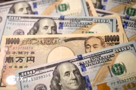 Đồng tiền 10.000 yen của Nhật Bản và đồng 100 USD. (Ảnh: THX/TTXVN)