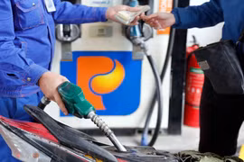 Khách hàng mua bán xăng, dầu tại một điểm kinh doanh xăng dầu của Petrolimex trên địa bàn Hà Nội. (Ảnh: Trần Việt /TTXVN)
