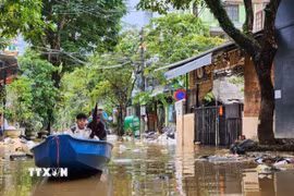 Người dân vẫn phải di chuyển bằng ghe trên đường phố Huế chiều 1/11. (Ảnh: Mai Trang/TTXVN)