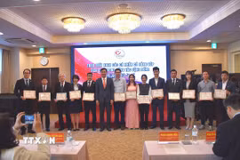 Đại sứ Phạm Quang Hiệu trao tặng giấy khen cho những cá nhân có đóng góp tích cực cho cộng đồng. (Ảnh: Nguyễn Tuyến/TTXVN)