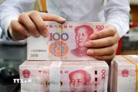Kiểm tiền mệnh giá 100 nhân dân tệ tại một ngân hàng ở Nam Thông, tỉnh Giang Tô (Trung Quốc). (Ảnh: THX/TTXVN)