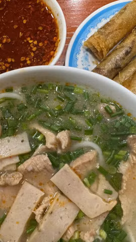 Cháo canh thường được ăn cùng ram - loại chả cuốn nhỏ được chiên vàng giòn. (Nguồn: Vietnam+)