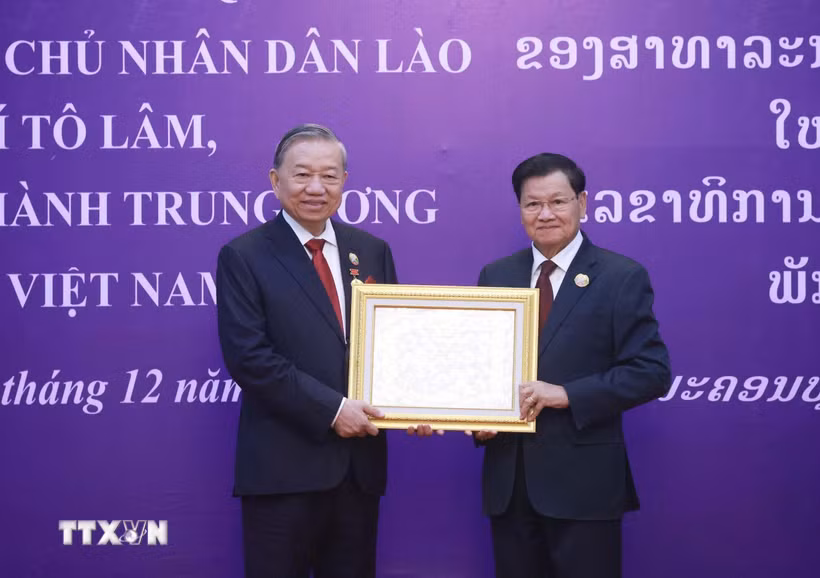 Tổng Bí thư, Chủ tịch nước Lào Thongloun Sisoulith trao tặng Huân chương Vàng Quốc gia của Nhà nước Lào cho Tổng Bí thư Tô Lâm. (Ảnh: Thống Nhất/TTXVN)
