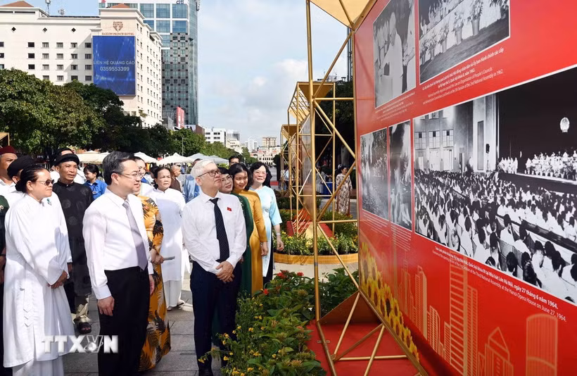 Ông Nguyễn Văn Lợi, Trưởng Đoàn đại biểu Quốc hội thành phố, ông Nguyễn Thanh Nghị, Phó Bí thư Thường trực Thành ủy Thành phố Hồ Chí Minh cùng các đại biểu tham quan Triển lãm ảnh chủ đề 'Vinh quang 80 năm Quốc hội Việt Nam.' (Ảnh: Xuân Khu/TTXVN)