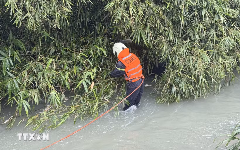 Lực lượng chức năng tỉnh Đồng Nai tìm kiếm chiếc ôtô bị nước cuốn trôi tại khu vực cầu Lộc Lâm. (Ảnh: Lê Xuân/TTXVN)