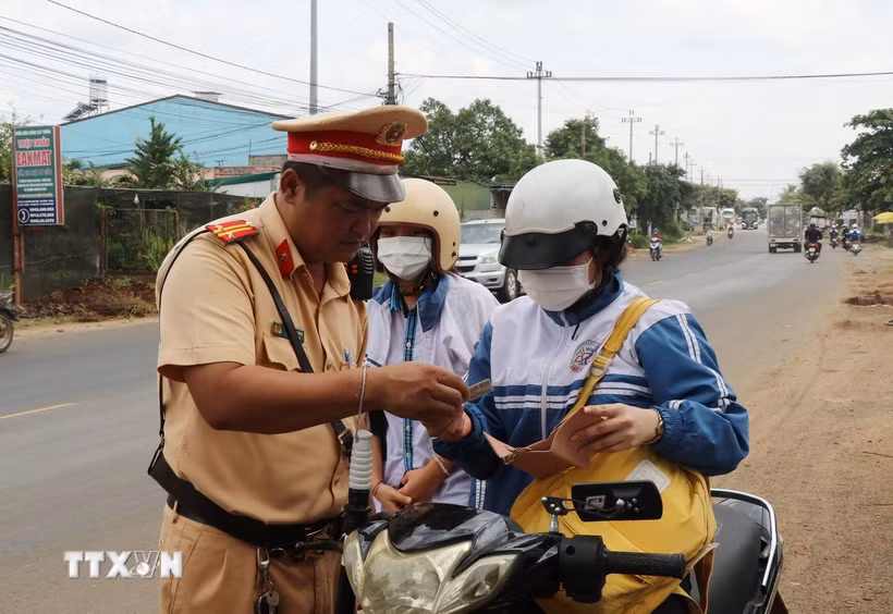 Lực lượng chức năng tuần tra kiểm soát giao thông kết hợp với tuyên truyền nhắc nhở học sinh tham gia giao thông đảm bảo các quy định của pháp luật. (Ảnh: Tuấn Anh/TTXVN)