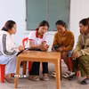 Thành viên Tổ công nghệ số cộng đồng “cầm tay chỉ việc” cho người dân. (Ảnh: Đặng Tuấn/TTXVN).